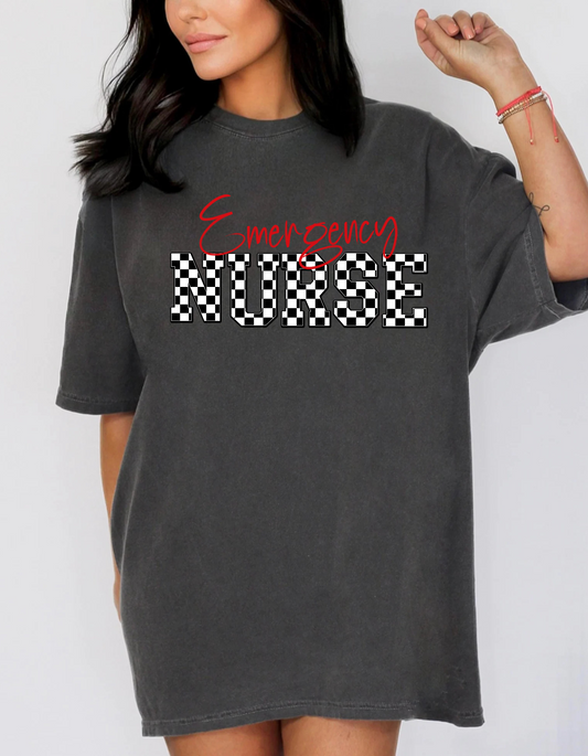 photo of girl wearing a Comfort Colors T shirt in the color Pepper gray with words across front in red Emergency below in black and white checkered nurse 